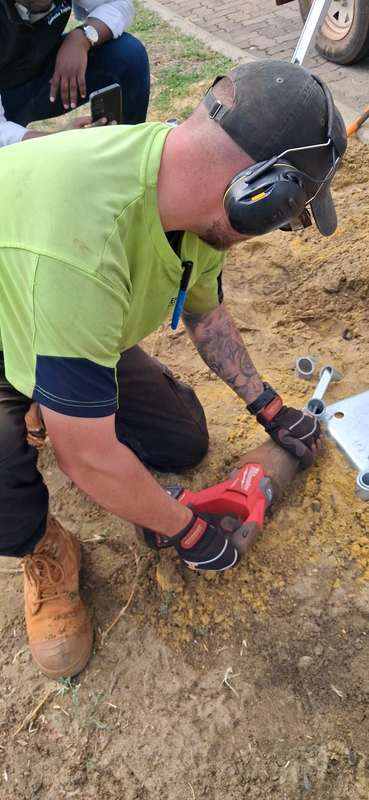 KOOLARK HOMES site worker using a power tool beside a galvanised footing bracket