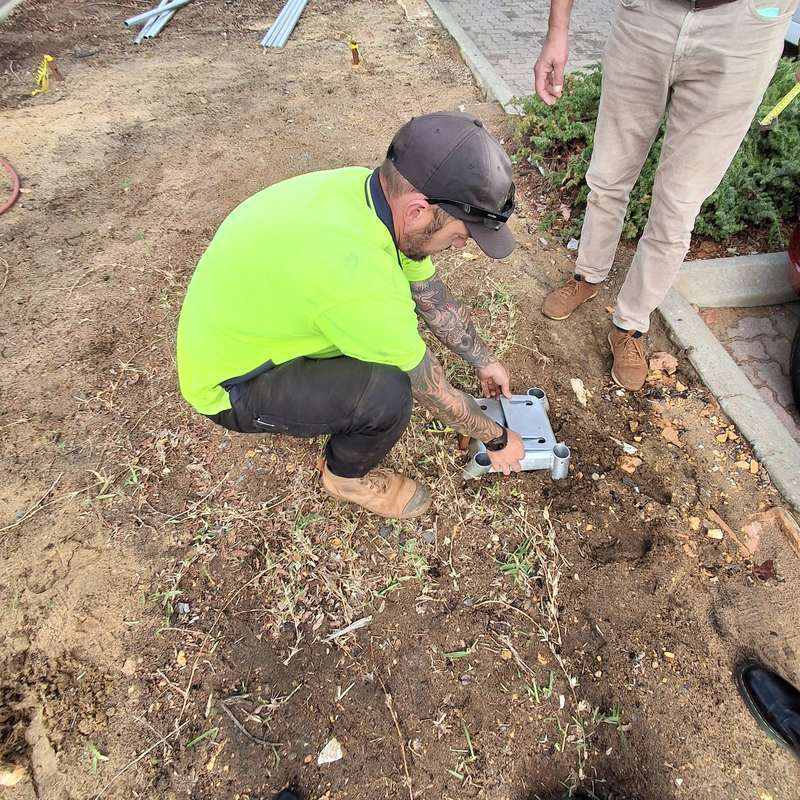 KOOLARK HOMES site worker positioning a galvanised footing bracket in prepared ground