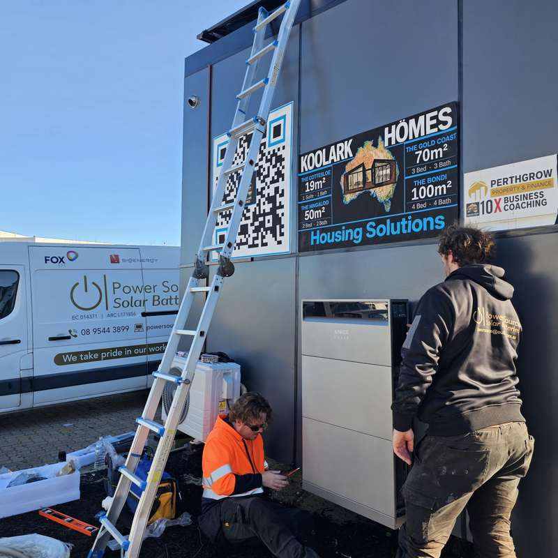 KOOLARK HOMES Homebase display with Anker SOLIX battery, Power Source Solar Batteries van and two unidentified workers