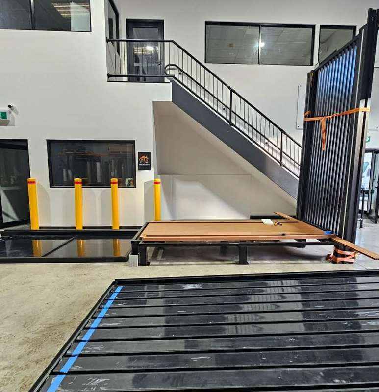 KOOLARK HOMES product-reference image showing a factory interior with black frame components and a staircase