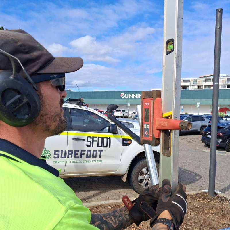 Surefoot footing level check beside a Surefoot-branded vehicle for a KOOLARK HOMES installation context